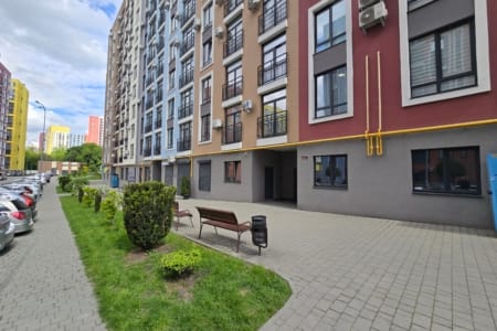 Footpath, lawn and bench by a building in the Semytsvit complex in Lviv