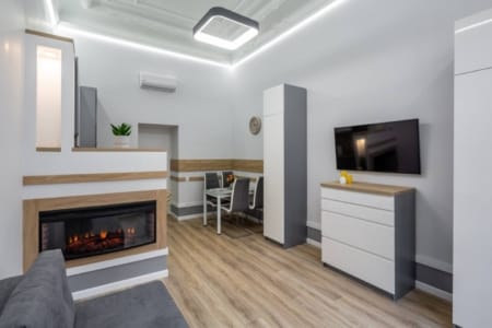 Вітальня з електрокаміном, телевізором і обіднім столом у квартирі на вул. Дорошенка