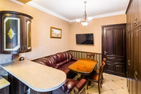 Kuchnia z barem, skórzaną sofą i telewizorem w apartamencie przy placu Danyła Halickiego