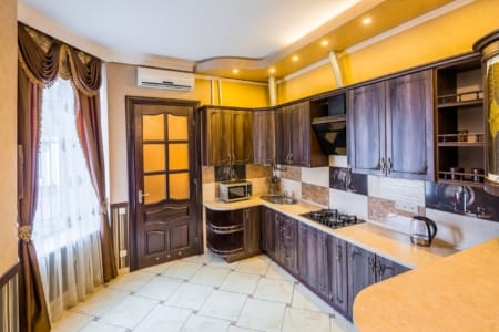 Kuchnia z drewnianymi frontami i kuchenką gazową w apartamencie przy placu Danyła Halickiego