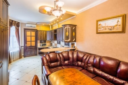 Kuchnia z salonem i skórzaną narożną sofą w apartamencie przy placu Danyła Halickiego