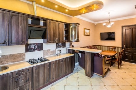 Kuchnia z kuchenką gazową, okapem i barem w apartamencie przy placu Danyła Halickiego