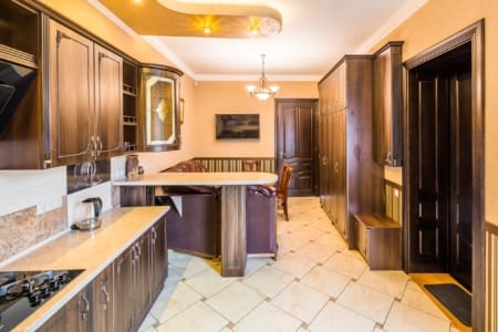 Przestronna kuchnia z barem i drzwiami wejściowymi w apartamencie przy placu Danyła Halickiego