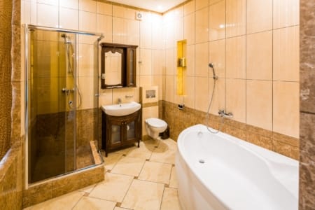 Łazienka z wanną narożną i kabiną prysznicową w apartamencie przy placu Danyła Halickiego