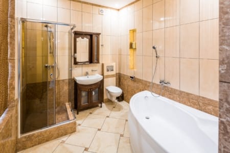 Wanna, kabina prysznicowa i umywalka z szafką w apartamencie przy placu Danyła Halickiego