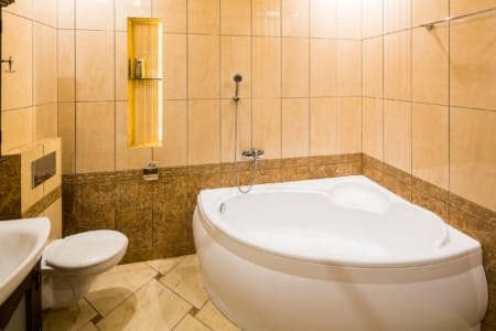 Łazienka z wanną narożną i podświetloną niszą w apartamencie przy placu Danyła Halickiego