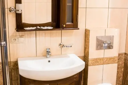 Umywalka z drewnianą szafką z lustrem w łazience, apartament przy placu Danyła Halickiego