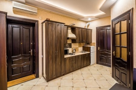 Кухня з дерев'яними шафами та вхідні двері у квартирі на площі Данила Галицького