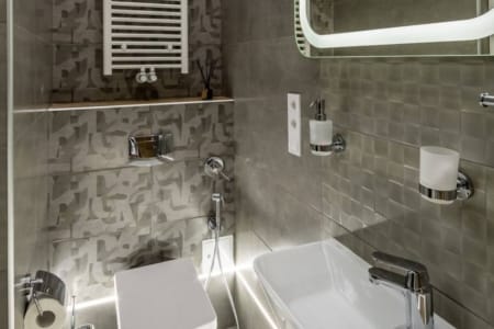 Bathroom with a heated towel rail and washbasin in the studio apartment on Doroshenka Street