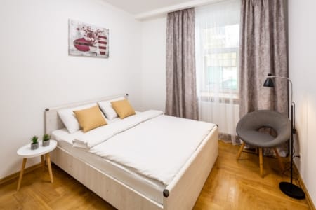 Bedroom with a double bed, armchair and floor lamp in the Krakivska Street apartment