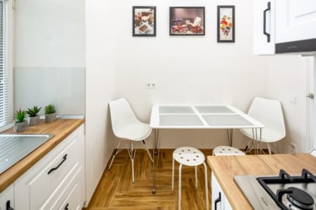 Dining table with white chairs in the kitchen of the Krakivska Street apartment