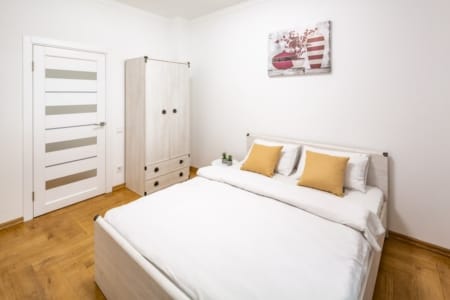 Bedroom with a double bed and wardrobe in the Krakivska Street apartment