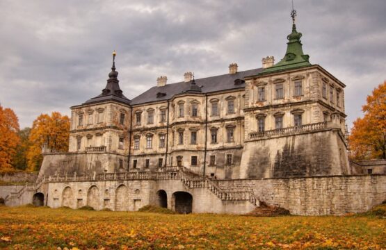 Zamek w Podhorcach jesienią: pałac na murach bastionowych ze schodami i arkadami