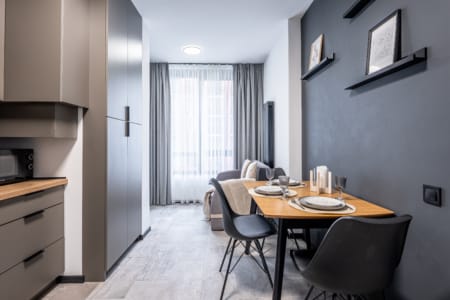 Kitchen and dining table by the window in the modern studio apartment in the Semytsvit complex