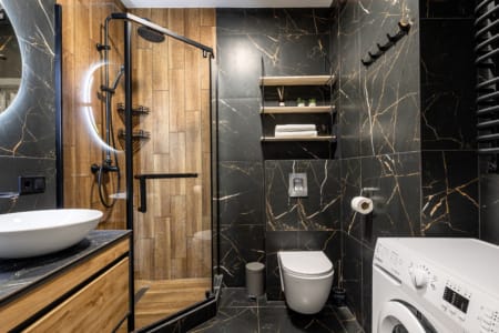 Bathroom with a shower cabin, wall-hung toilet and washing machine, apartment in the Semytsvit complex