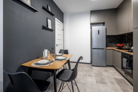 Dining area, fridge and kitchen in the modern studio apartment in the Semytsvit complex