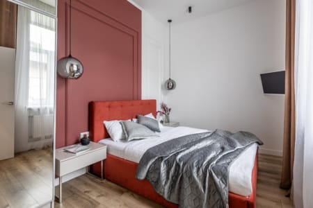 Bedroom with a mirrored wardrobe and a terracotta bed in the apartment on Zamarstynivska Street