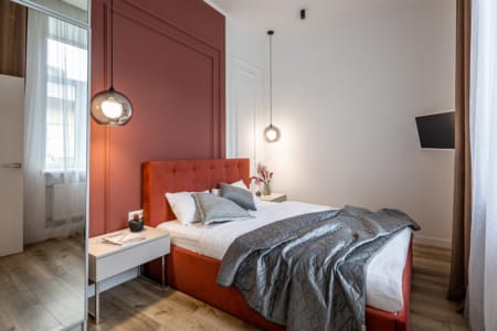 Bedroom with a bedside table, lamp and bed in the apartment on Zamarstynivska Street