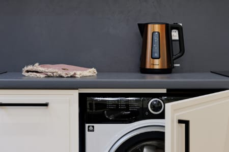 Pralka i czajnik elektryczny w kuchni apartamentu przy ul. Doroszenki