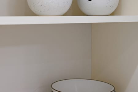 Talerze i miski na półce szafki kuchennej w apartamencie przy ul. Doroszenki
