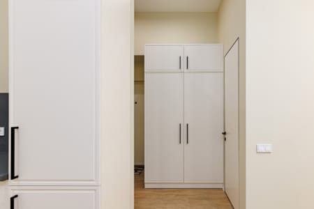 Przedpokój z białą szafą wnękową w apartamencie przy ul. Doroszenki