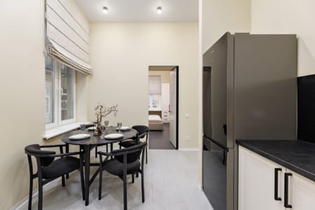 Dining area by the window and a view into the bedroom, apartment on Doroshenka Street