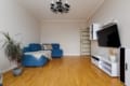 Living room with a blue corner sofa and TV in the apartment on Pluhova Street