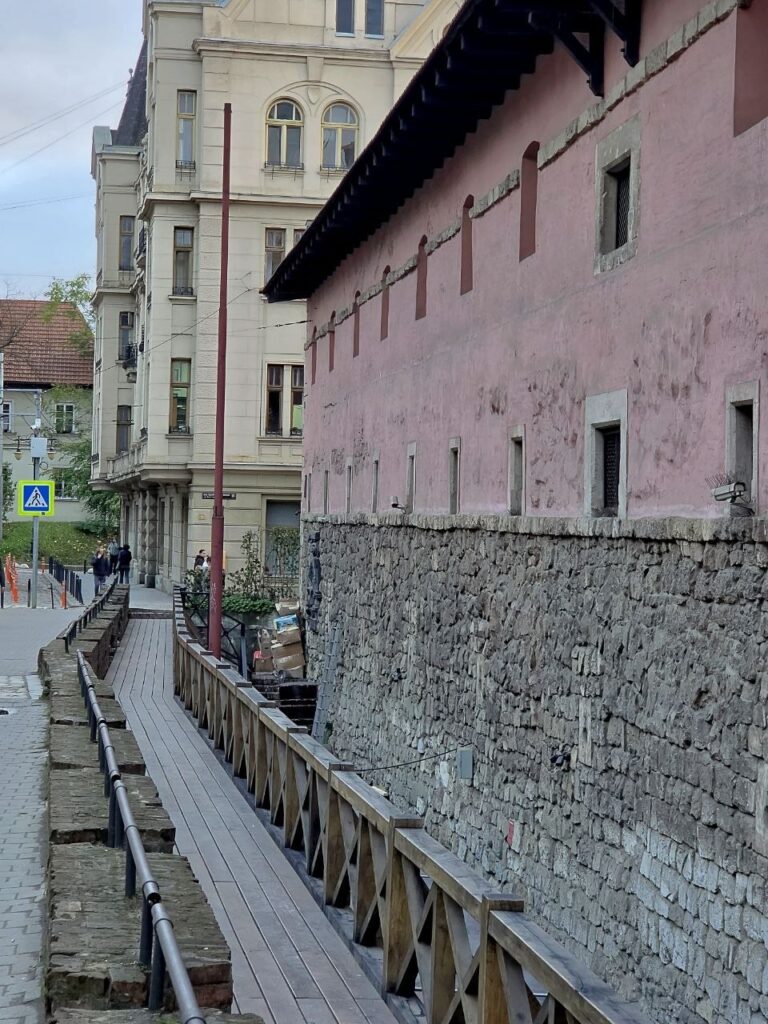 Мури Міського арсеналу | Leo Apartment Масивні мури й кам’яний цоколь Міського арсеналу над лінією колишнього оборонного рову на вулиці Підвальній