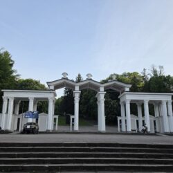Біла колонада з арками на центральному вході в Парк культури у Львові
